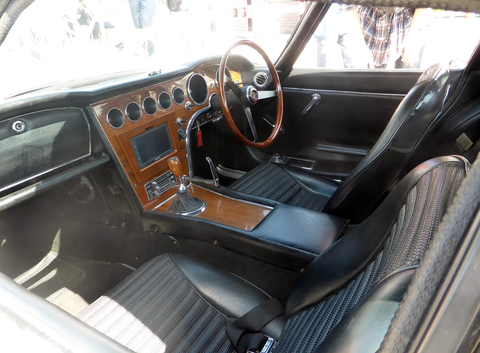 2000GT（MF10 前期型）的座舱：木饰仪表台、秒表与电子钟透露其 GT 定位 · 图像文件署名：Tokumeigakarinoaoshima；CC0；网页缩放，原始文件保留。