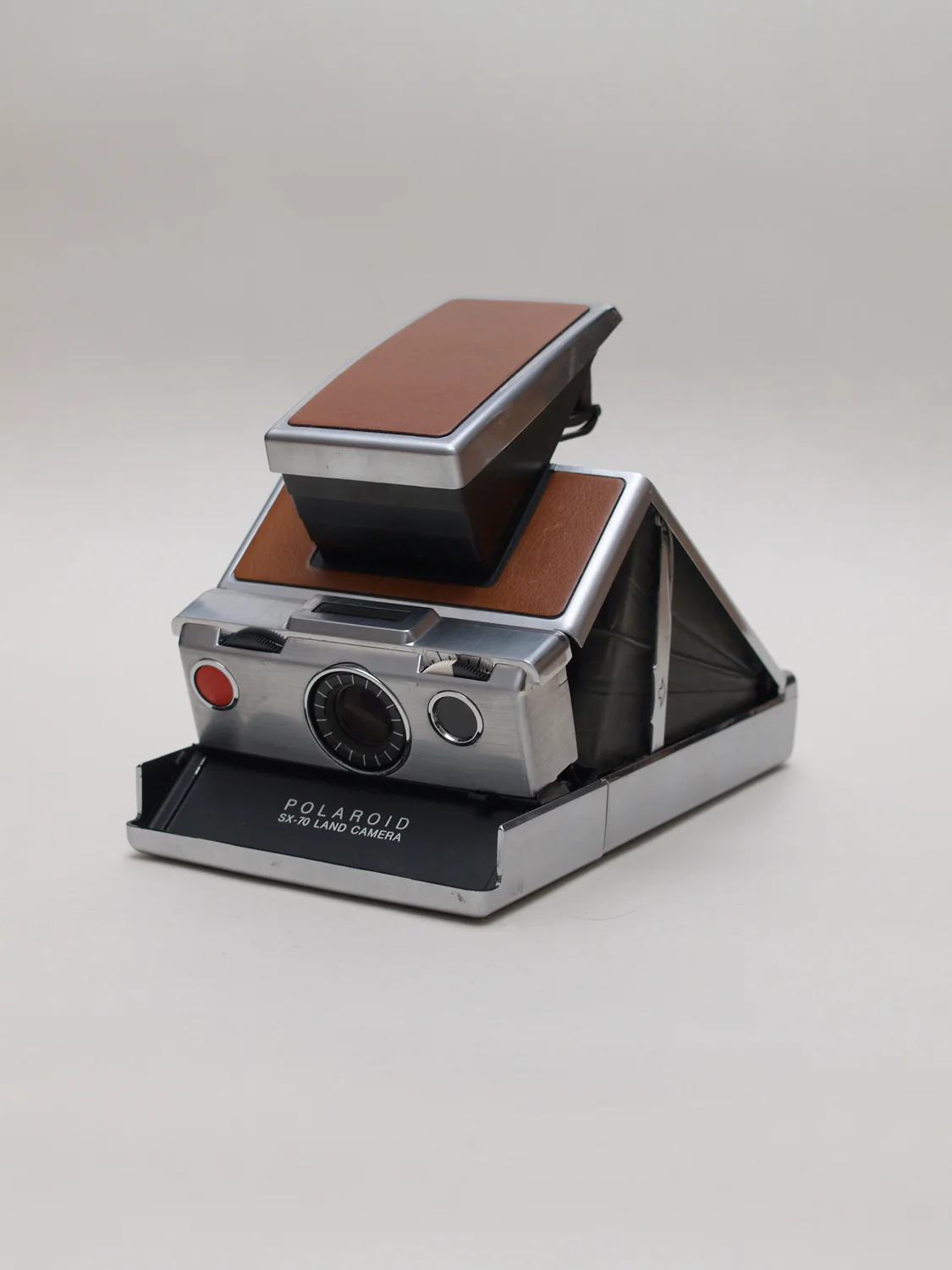 SX-70 折叠态与展开态之间：单镜头反光结构被压进 2 厘米级的折叠厚度。