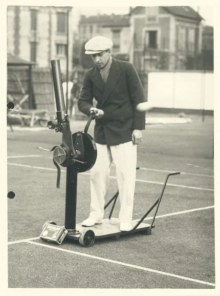 René Lacoste 与发球装置的历史照片；官方档案标为 1926 年，此图不对应后来的球拍专利。 © Keystone · Lacoste 官方档案。（档案原图分辨率有限，未人工放大。）