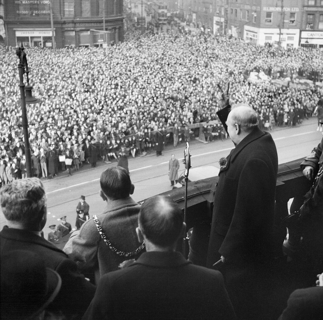 英国战争部官方摄影师摄，公有领域——Winston Churchill gives his famous 'V for Victory' sign, Sheffield, November 1941（注意：此为 1941 年 11 月丘吉尔在谢菲尔德的另一档案照，非卡什那张）