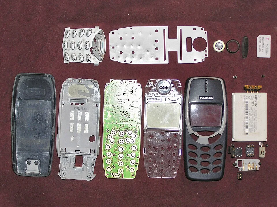 Nokia 3310 拆解图：主板、机壳、键盘模块的分离证明了这种设备在物理上的可修复性。 screw badluck / Wikimedia Commons, CC BY-SA 2.0。 · 图像文件署名：screw badluck；CC BY-SA 2.0；网页缩放，原始文件保留。