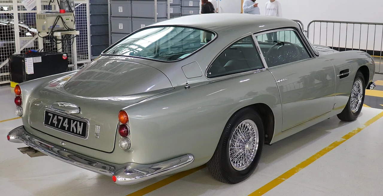 1964 年款 DB5 尾部，摄于 Gaydon 工厂；注意快背轮廓与沿用自 DB4 Series V 的凹嵌式尾灯；摄影 Vauxford，CC BY-SA 4.0（Wikimedia Commons）
