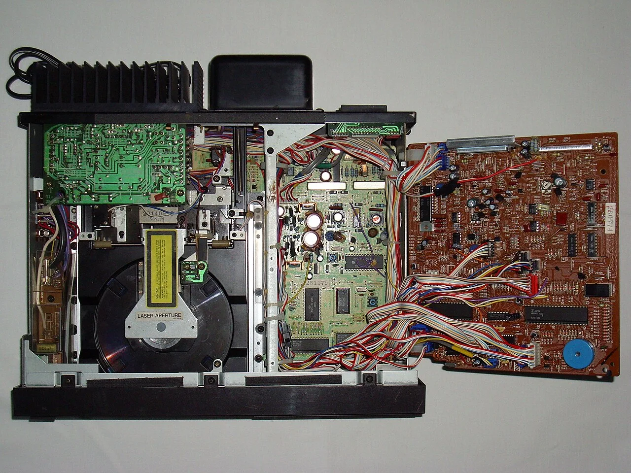 Sony CDP-101 的机芯与内部结构，摄影 Atreyu，CC BY 2.5，图片来源：Wikimedia Commons。此图展示的是打开机壳后的内部，可看到滑出式托盘机构与电路布局。