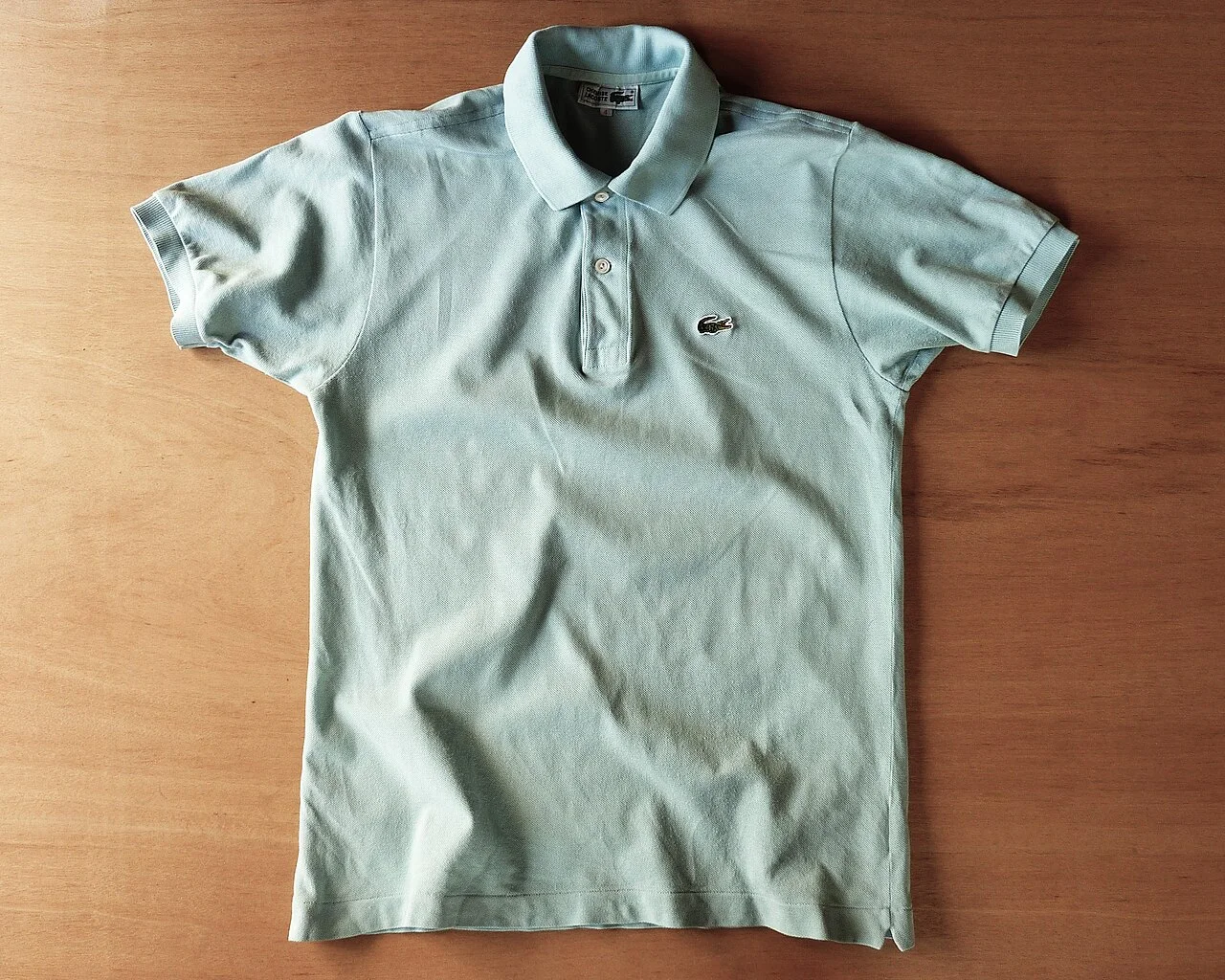 一件1990年代的Lacoste polo衫。尽管全球通行称之为"polo shirt",这个名字其实来自马球运动,与Lacoste无关。 · 图像文件署名:Quercus acuta;CC BY-SA 4.0;网页缩放,原始文件保留。