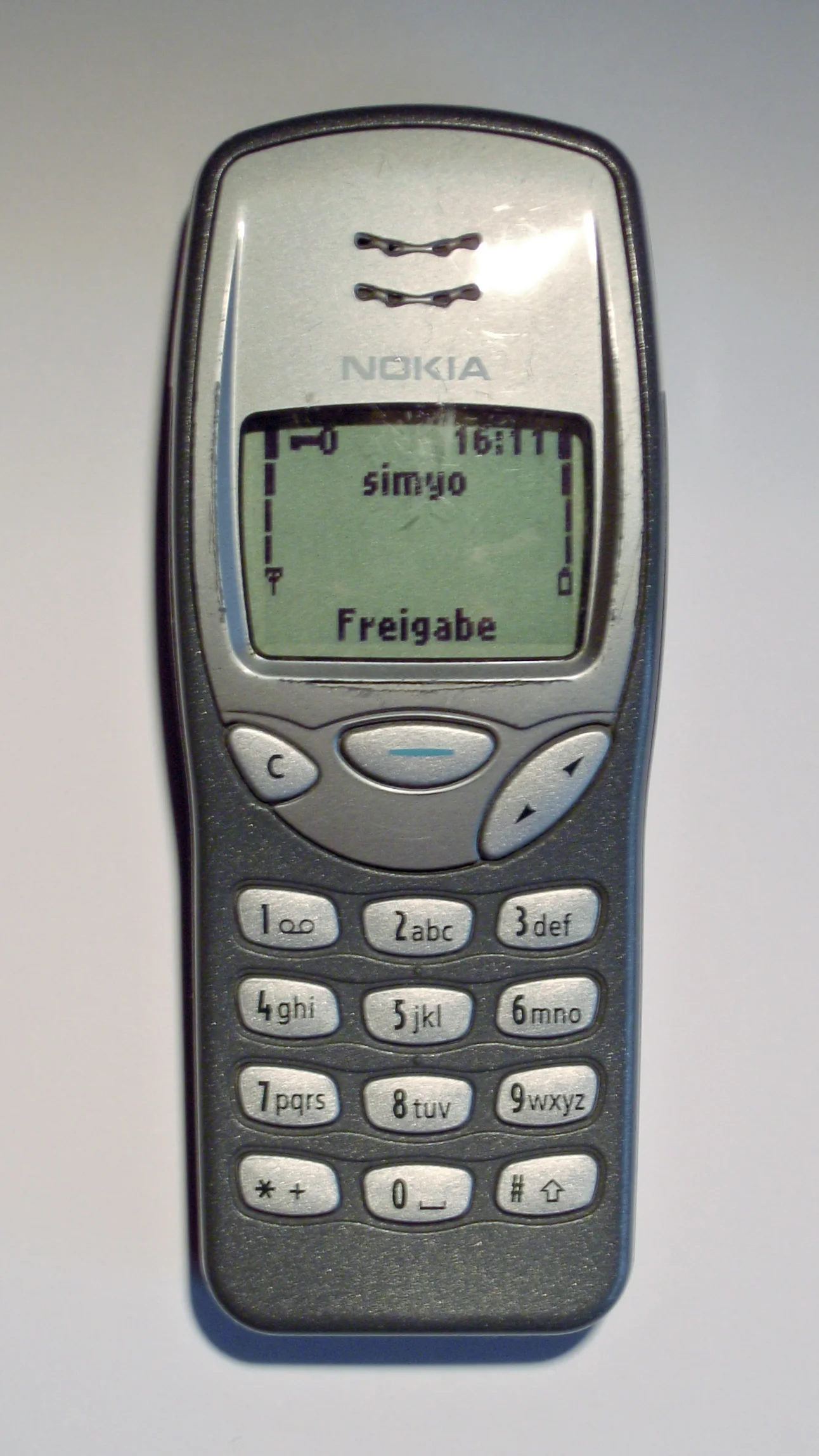 屏幕点亮的 Nokia 3210：绿色背光液晶屏。Basic.Master 摄（Wikimedia Commons），CC BY-SA 3.0。 · 图像文件署名：Basic.Master；CC BY-SA 3.0；网页缩放，原始文件保留。