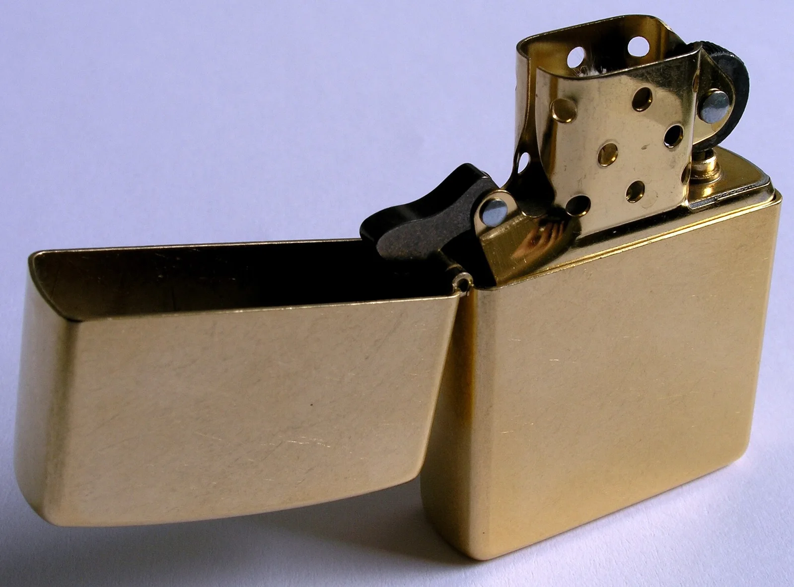Zippo 黄铜内胆:内胆从外壳中滑出,露出棉芯与火石机构 · 图像文件署名:Hardyg;Public domain;网页缩放,原始文件保留。