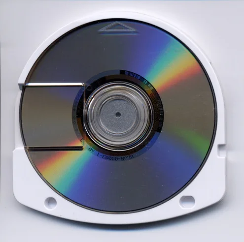 Universal Media Disc（UMD）光盘实物。PSP既用它发行游戏也发行电影，是其多媒体定位的物理载体。图：Takobou（日文维基百科用户）/ Wikimedia Commons，CC BY-SA 3.0。