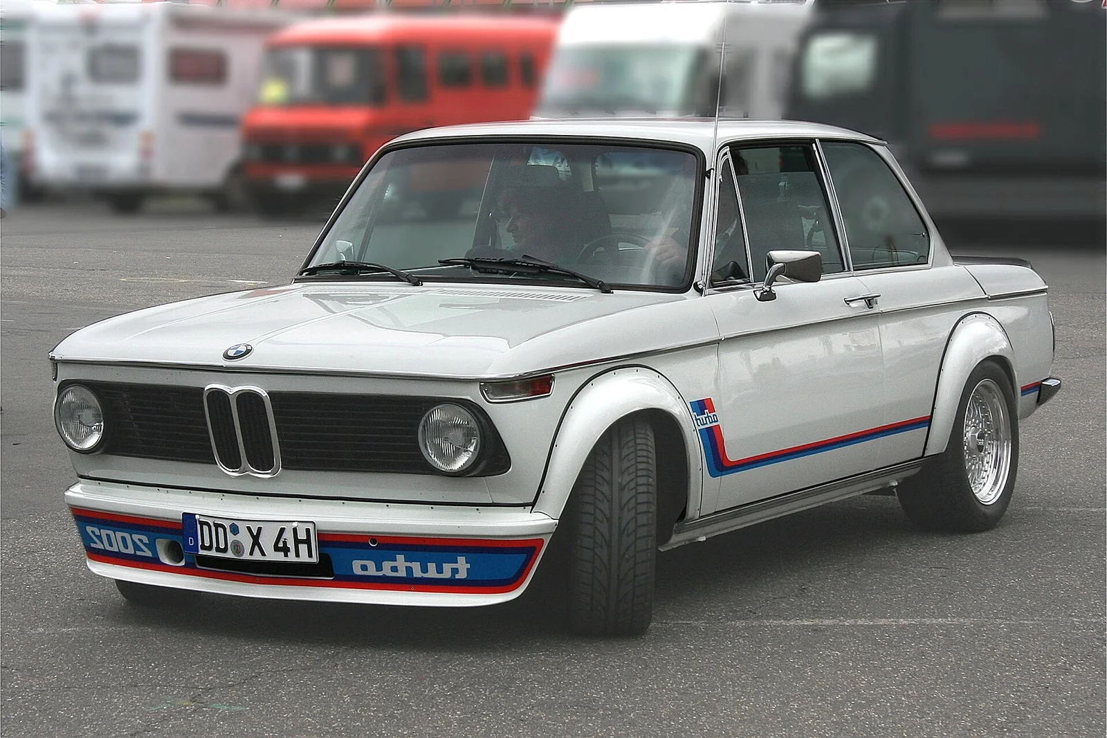 2002 Turbo（1973）：欧洲第一台涡轮增压量产车，玻璃钢轮眉、前扰流与反写贴纸是其全部身份标识 · 图像文件署名：Spurzem - Lothar Spurzem；CC BY-SA 2.0 de；网页缩放，原始文件保留。