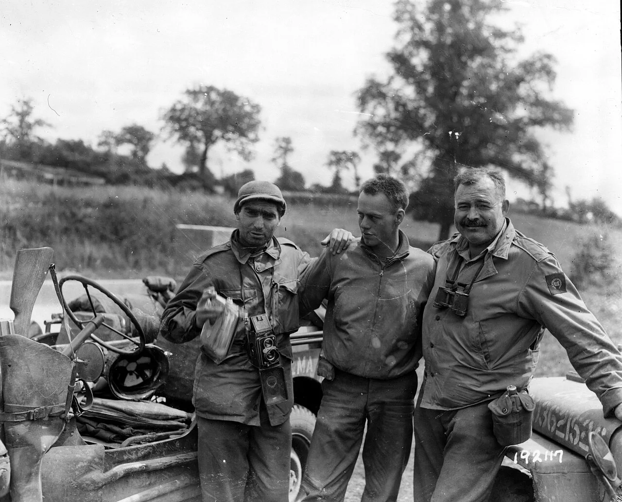 美国陆军通信兵摄,公有领域——卡帕(左)与海明威在法国前线,1944