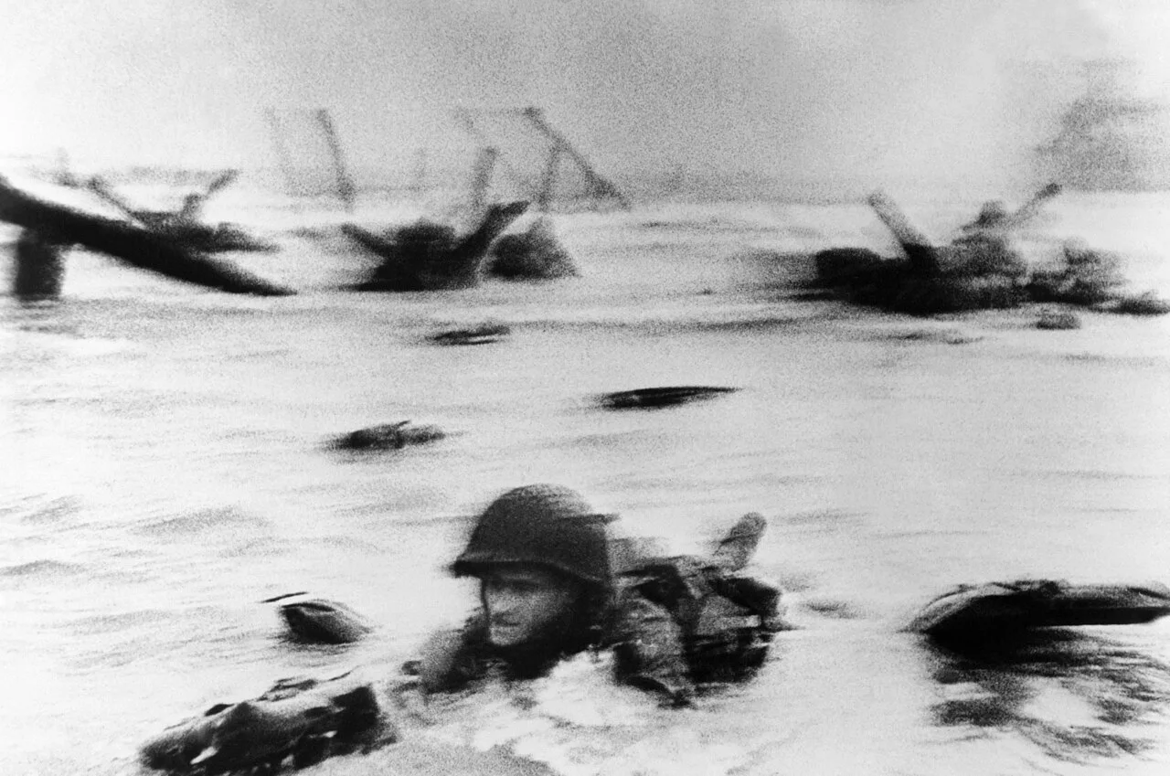 Robert Capa 摄，公有领域——"Face In the Surf"，1944