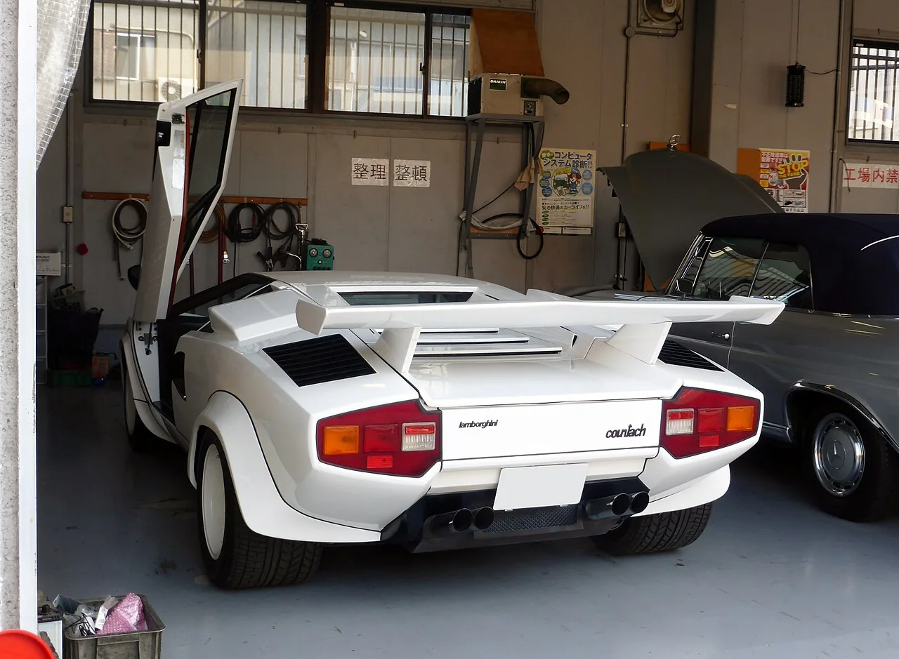 开启驾驶侧车门的 Countach LP400S（注意：此车为 1978 年后的 LP400S，非初代 LP400）——从车尾看剪刀门的开启轨迹