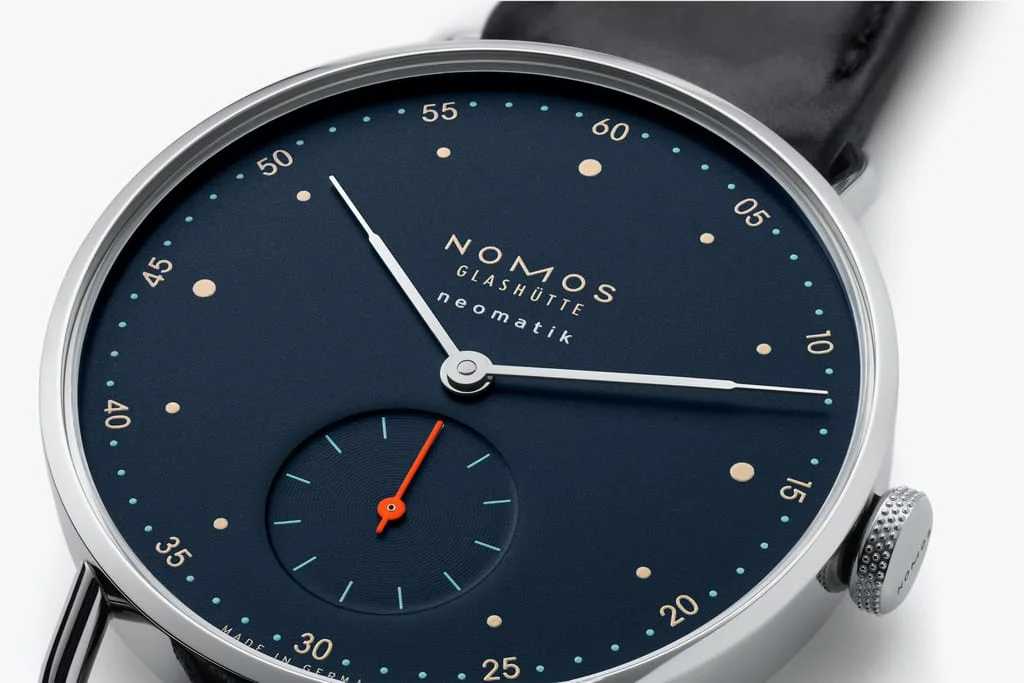 Metro neomatik 深色版本细节 · NOMOS Glashütte，摄影者未单列；非首发白盘